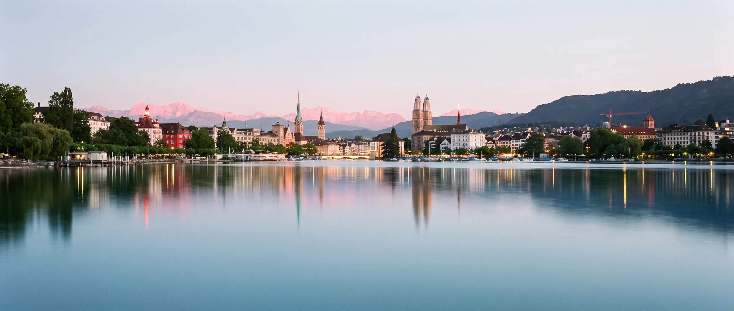 Zurich old town and church spires reflected in Lake Zurich at dusk